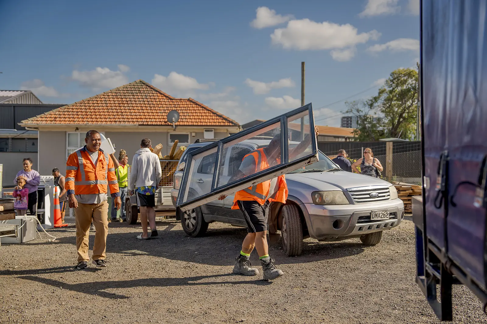 community members carry free salvaged window for reuse